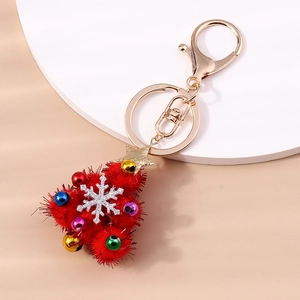 Detail of red pom-pom Christmas tree keychain with colorful bells and gold star