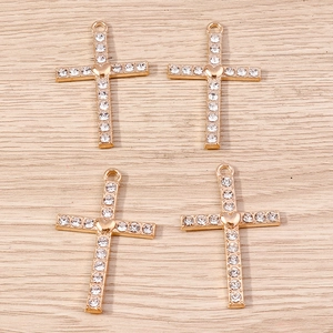 Macro detail of four gold-plated alloy heart cross pendants with white rhinestones