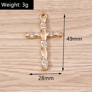 Detailed view of a gold cross pendant with clear rhinestones and dimensions shown