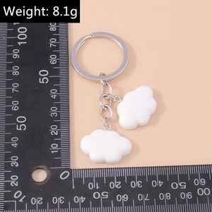 Detailed view of dual white cloud keychains with silver chain weighing 8.1g for bags