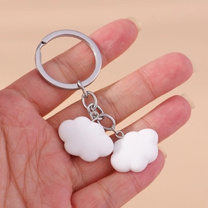 Detailed view of minimalist white cloud pendants on a silver metal keychain ring