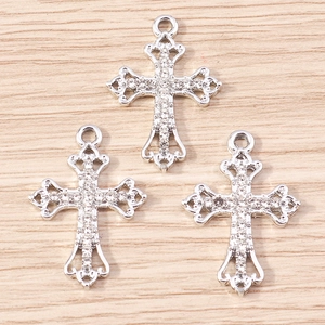Macro view of three silver alloy cross pendants with sparkling white zircon inlays