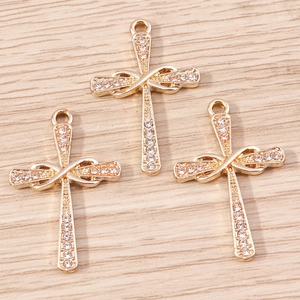 Detail of three gold alloy infinity cross pendants with sparkling inlaid rhinestones