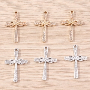 Detailed view of infinity cross pendants with sparkling rhinestones in gold and silver finish