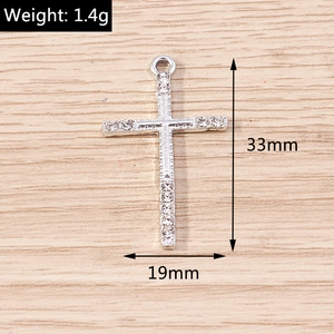 Detailed view of silver cross pendant showing 33mm by 19mm size and 1.4g weight