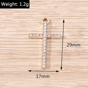 Detailed view of gold cross pendant with cubic zirconia stones showing 29x17mm dimensions