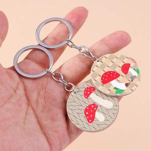 Détail de porte-clés champignons avec motifs rouges et blancs et anneaux en métal