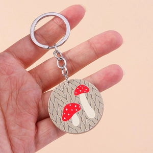 Détail d'un porte-clés rond en acrylique avec motif de champignon à la main