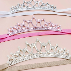 Detailed close-up of elastic rhinestone crown headbands with pearls for toddler girls