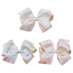 Three-piece set of brocade bow hair clips in ivory, light blue, and pink with gold hearts