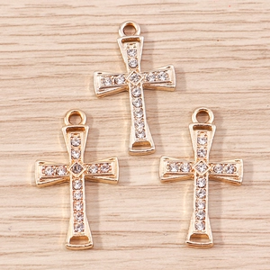 Macro detail of three gold plated alloy cross pendants with white sparkling rhinestones