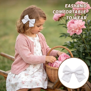 White linen bow hair clip worn by child model showing the texture and secure fit