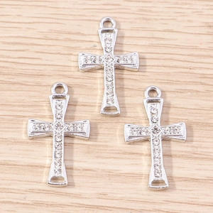 Macro detail of three silver alloy cross pendants inlaid with white rhinestones