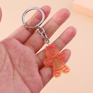 Détail d'un porte-clés en acrylique bonhomme de pain d'épices avec contour rouge et nœud rose