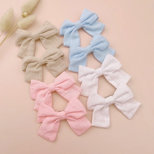 8-piece set of handmade linen bow hair clips for kids in beige, pink, and blue