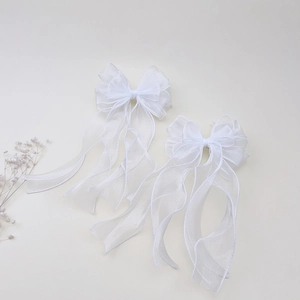 Dettaglio del fiocco in tulle bianco con lunghi nastri eleganti e texture delicata