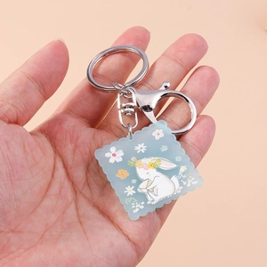 Détail d'un porte-clés lapin en acrylique avec étiquette bleue et fermoir homard
