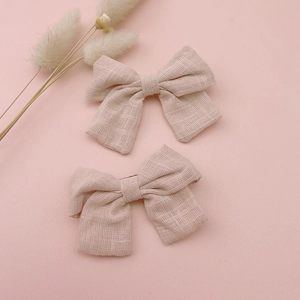 Detail view showing textured pink cotton linen fabric bow hair clips for girls