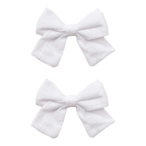 Detailed macro view of two white cotton-linen bow hair clips with soft woven textures