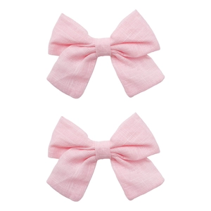 Detailed close-up of pink linen fabric bows showing natural textile texture and handcraft