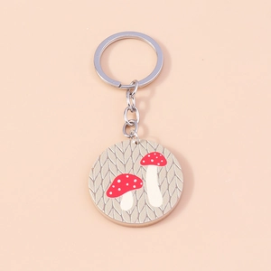 Détail du porte-clés avec breloque champignon à pois rouges et blancs sur beige
