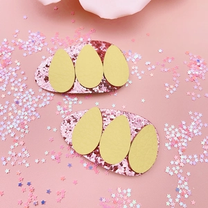Detail of pink glitter Easter bunny ear hair clips with yellow egg-shaped faux leather patches