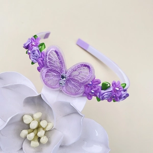 Détail du papillon en dentelle violette fait main et des fleurs en tissu sur le serre-tête
