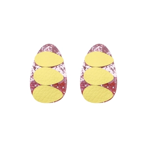Close-up of Easter egg hair clips with pink glitter base and yellow faux leather textures