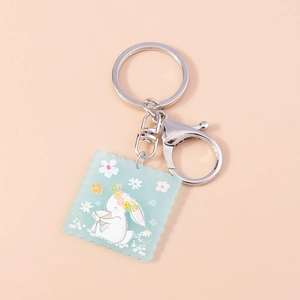 Détail du porte-clés en acrylique lapin blanc avec motifs floraux et fermoir argenté