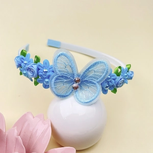 Détail d'un serre-tête papillon en dentelle bleue avec perles pour filles