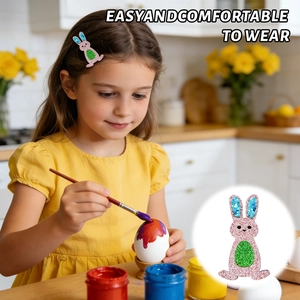 Detailed view of a glittery Easter bunny hair clip worn by a young girl while painting eggs