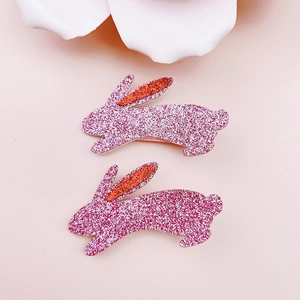 Close-up of pink glitter Easter bunny hair clips for girls with cute floral decorations