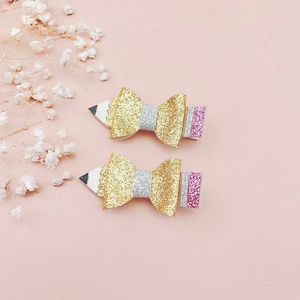 Dettaglio di fermagli per capelli a matita glitterati per bambine su rosa