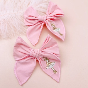 Detailed embroidery of a ballerina on pink fabric bows with scalloped edge craftsmanship