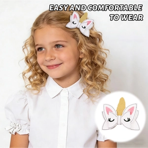 Detailed view of the white leather unicorn bow hair clip with gold glitter horn and embroidery
