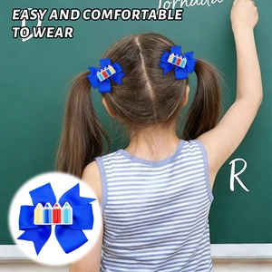 Close-up of blue grosgrain ribbon bow hair clip with colorful pencil motif for school