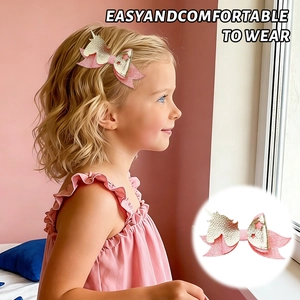 Close-up of pink and gold glitter unicorn hair bow clip worn by a young girl