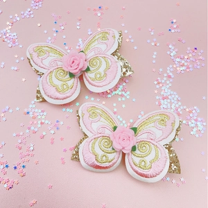 Détail de barrettes papillon multicouches avec broderie florale et texture pailletée
