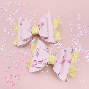 Détail de barrettes noeud rose avec motifs de patins et tissu pailleté doré