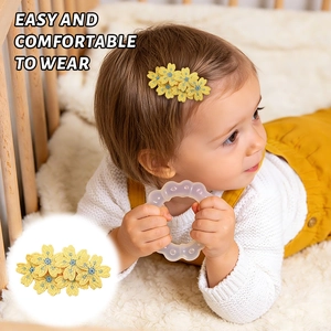 Detail of yellow embroidered flower hair clip for kids on soft fabric background