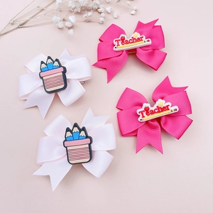 Detail view of pink bow hair clips with blue pencil holder and teacher theme decor
