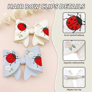 Detail of embroidered ladybug and daisy on PU leather bow clips with metal duckbill clip