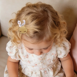 Dettaglio del fermaglio per capelli a forma di coniglio floreale indossato da una bimba
