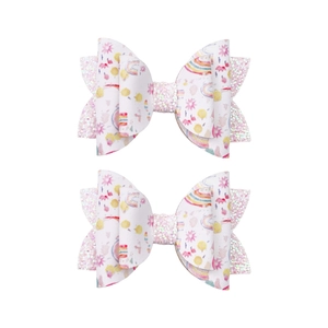Détail de paillettes roses et motifs floraux sur un ensemble de 2 pinces à cheveux papillon