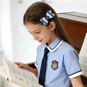 Détail d'un nœud papillon scolaire avec décor ABC et motifs de crayons sur les cheveux