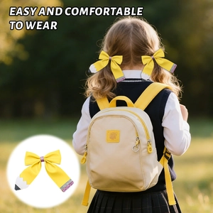 Détail d'une barrette à cheveux nœud crayon pailleté pour enfants sur fond de pelouse