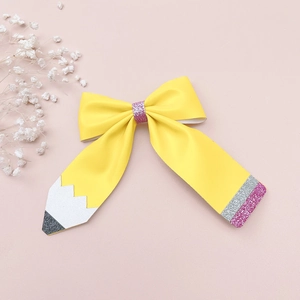 Détail du nœud papillon en cuir pailleté motif crayon avec sequins sur fond rose
