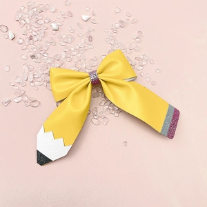 Détail d'un nœud à cheveux pailleté en forme de crayon avec accents roses et jaunes