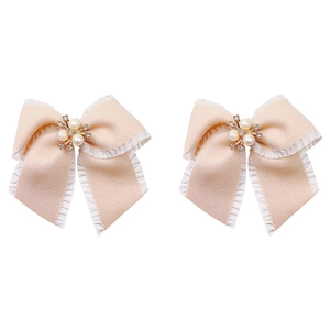 Dettagli di fiocchi in nastro beige con centri decorati con perle e strass