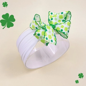 St. Patrick's Day baby headband with green shamrock pattern bow on white nylon strap
